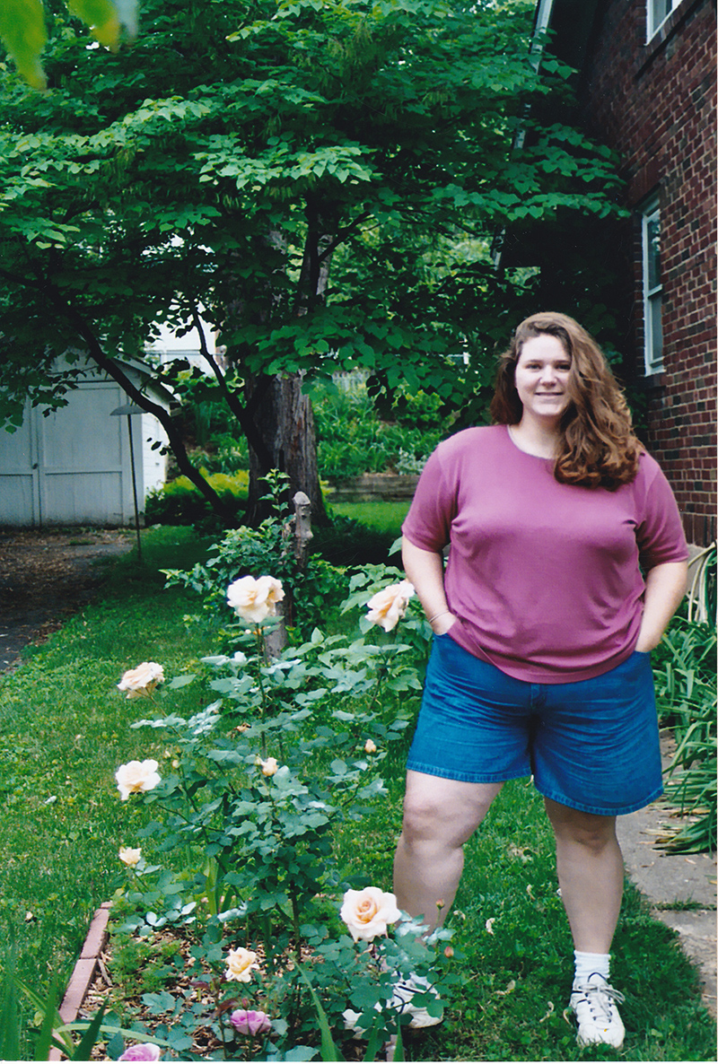 Margaret standing next to rose bush